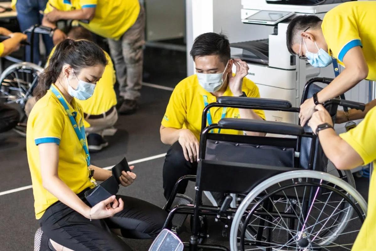 Top 12 Best Team Building Companies In Malaysia 2025 5 Participants fixing a wheel chair as part of the CSR activity