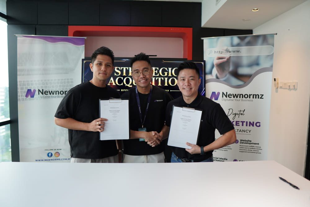 Newnormz Just Got Bigger And Malaysian Businesses Are Set to Benefit 1 Newnormz and Weitzen representatives holding signed documents after completing the strategic acquisition agreement.